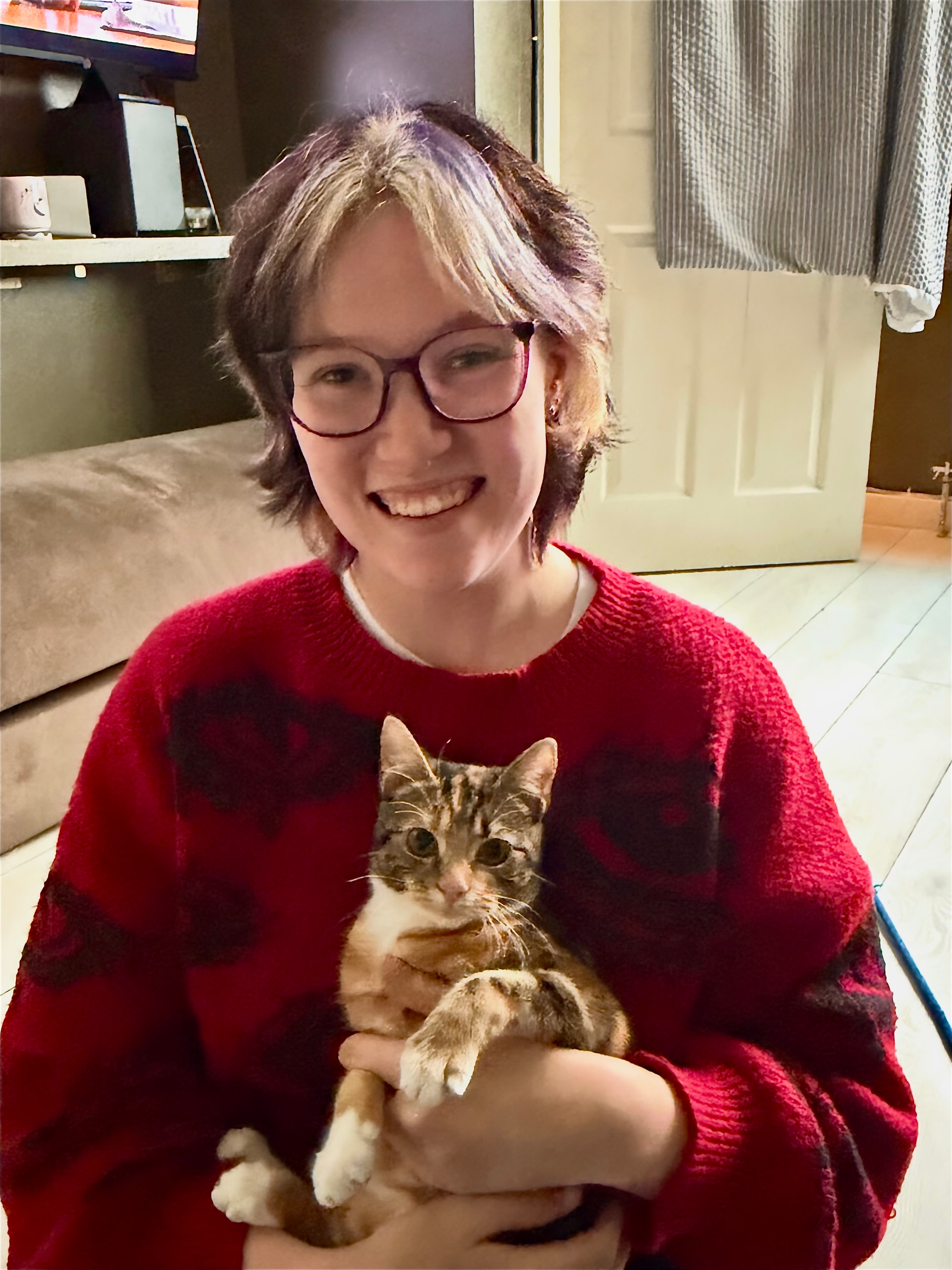 The Treeton Tails sitter holding a cat indoors